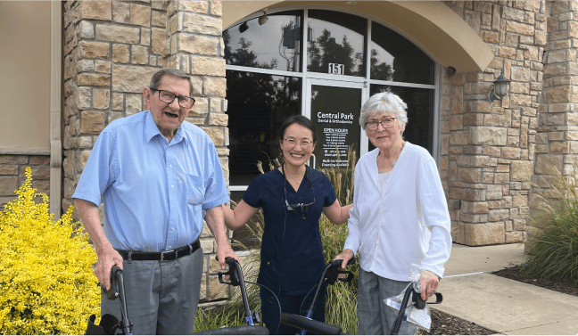 Dr. Jung, our dentist in Mansfield, infront of her dental practice with two elderly patients.