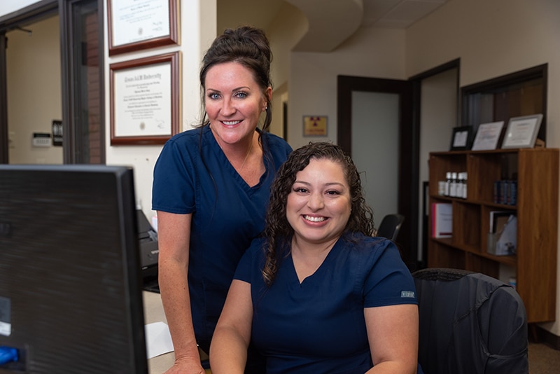 receptionists smiling at dental practice in Arlington tx